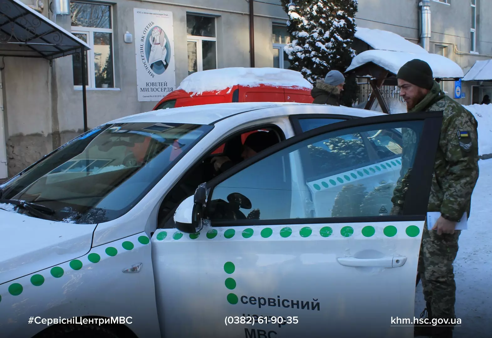Ветеран у військовій формі сідає в авто з логотипом сервісного центру МВС на засніженій вулиці