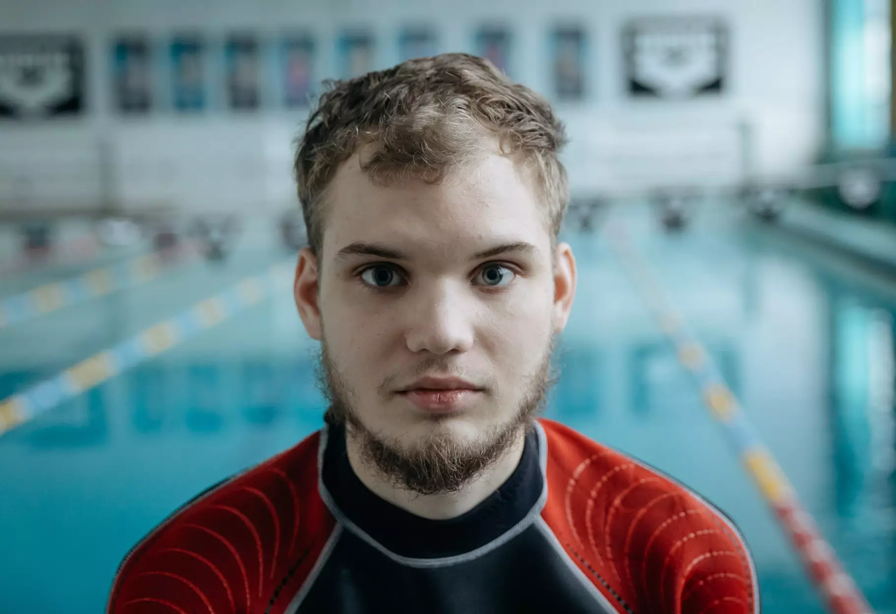 Молодий чоловік у гідрокостюмі біля басейну, підготовка до занять з дайвінгу для реабілітації ветеранів