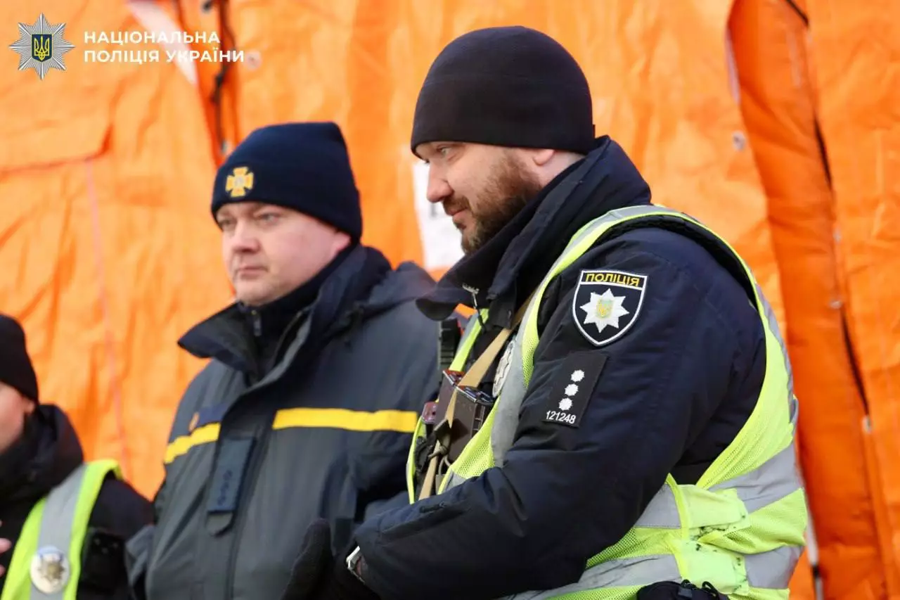 Поліцейські у формі на фоні помаранчевих наметів під час виконання службових обов'язків у Києві