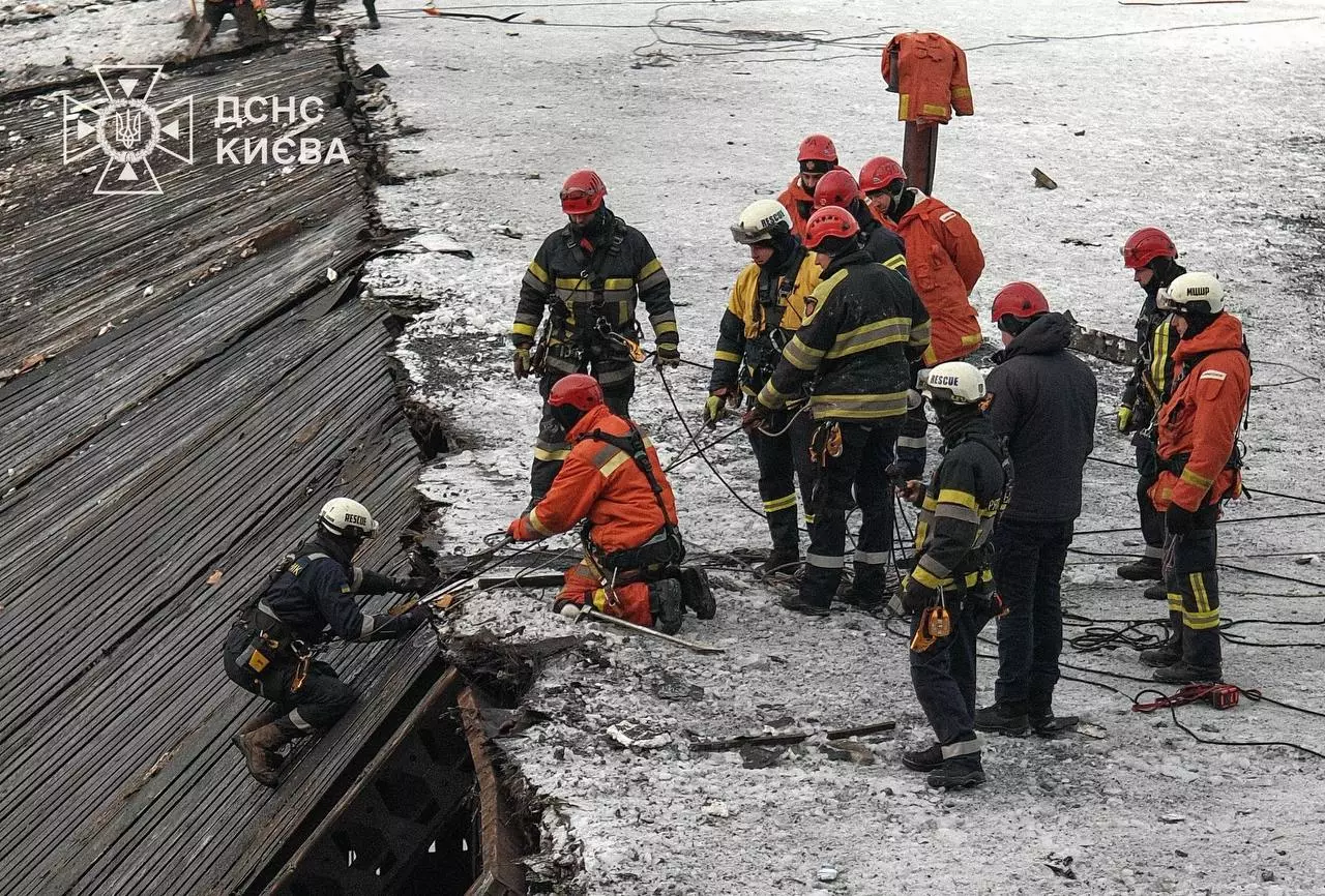Рятувальники ДСНС у захисному одязі працюють на зруйнованому даху в умовах сильного морозу