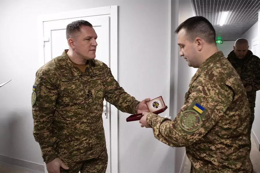 Командувач НГУ вручає нагороду військовослужбовцю у камуфляжній формі в коридорі військової бази