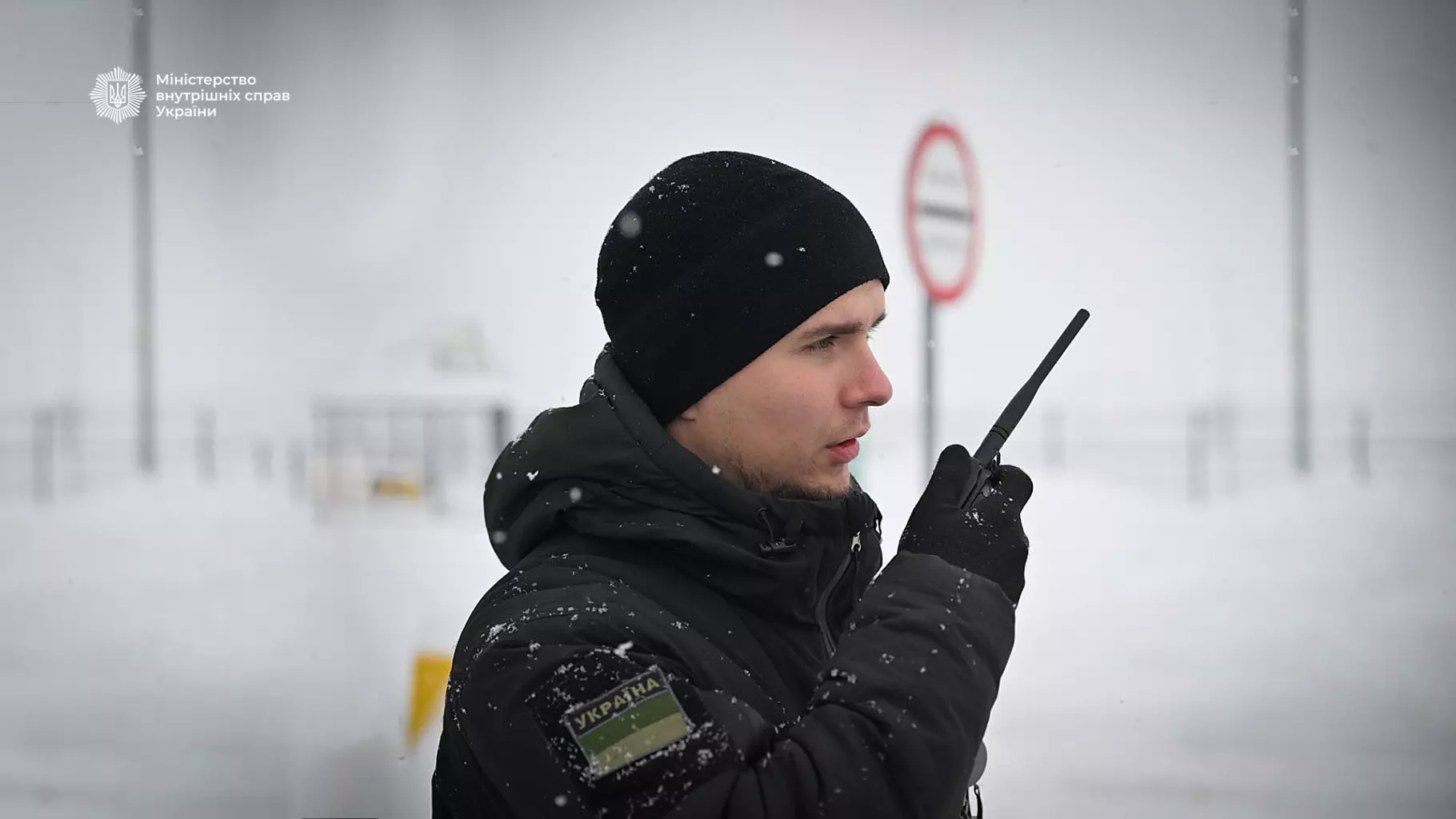 Прикордонник у зимовій формі з рацією на фоні сніжного пейзажу, забезпечує безпеку на кордоні