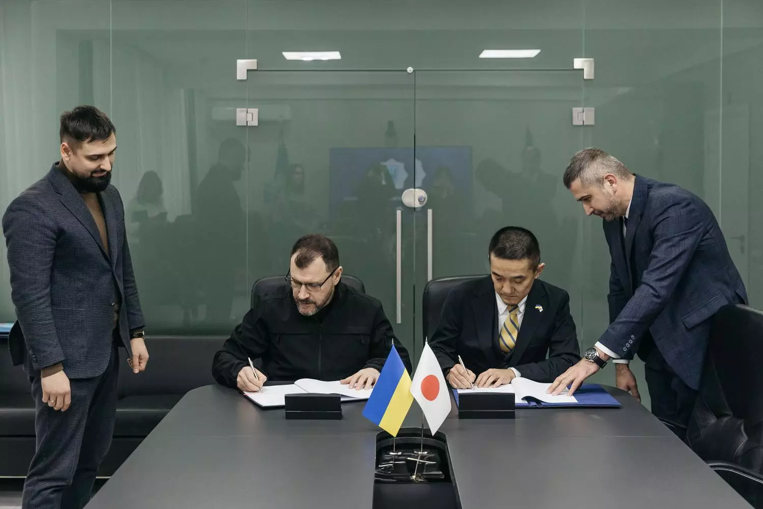 Міністр України та представник JICA підписують угоду про гуманітарне розмінування за столом з прапорами