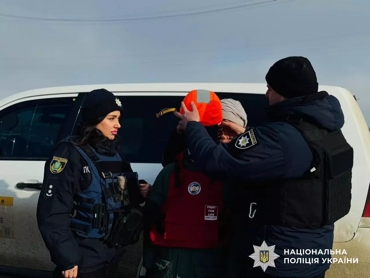 Поліцейські та волонтери допомагають родині з дітьми під час евакуації в Херсонській області