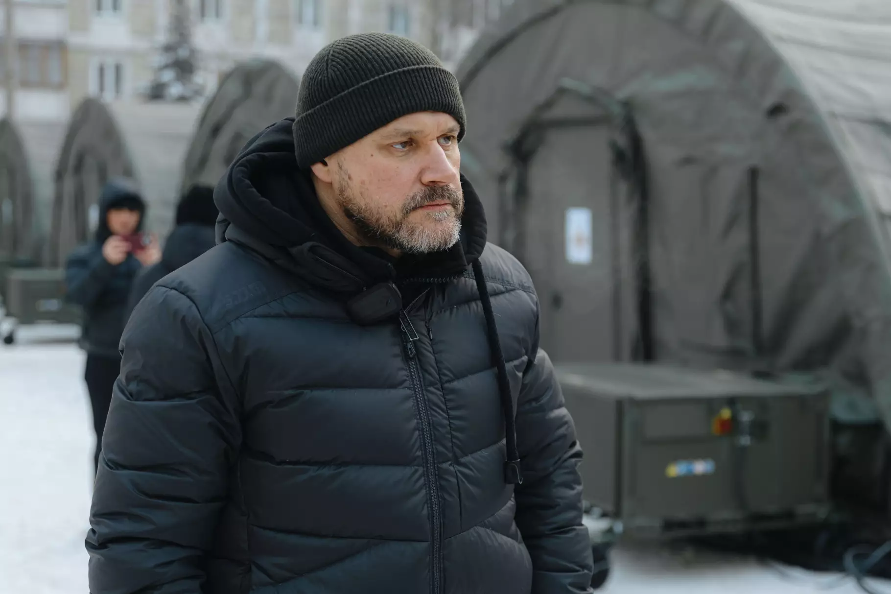 Міністр на фоні наметового містечка ДСНС на Троєщині після обстрілів, зима, люди в теплих куртках