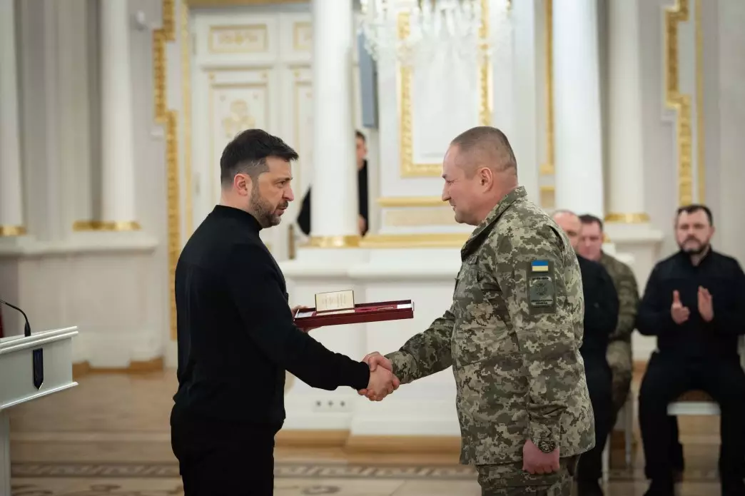 Президент України вручає нагороду військовослужбовцю у камуфляжі під час урочистої церемонії в залі