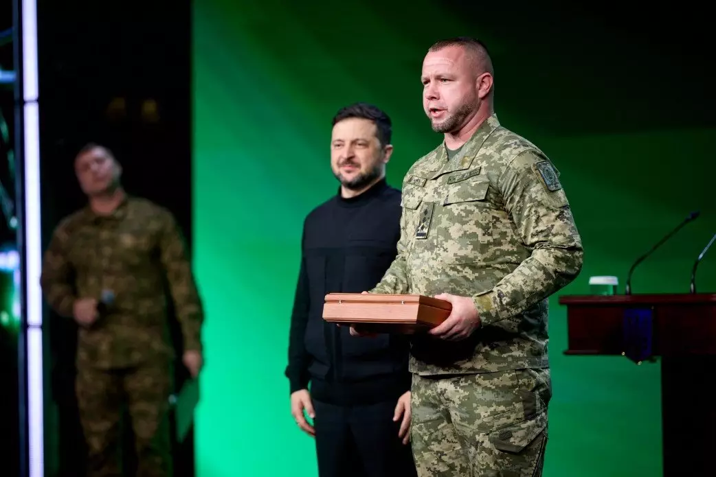 Президент України вручає нагороду військовослужбовцю у формі на урочистій церемонії