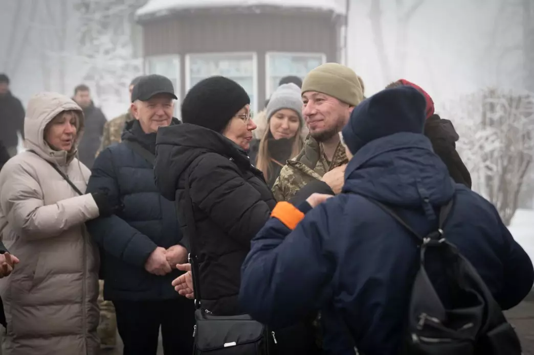 Люди в зимовому одязі спілкуються на вулиці під час вшанування пам'яті Героїв Крут у Києві