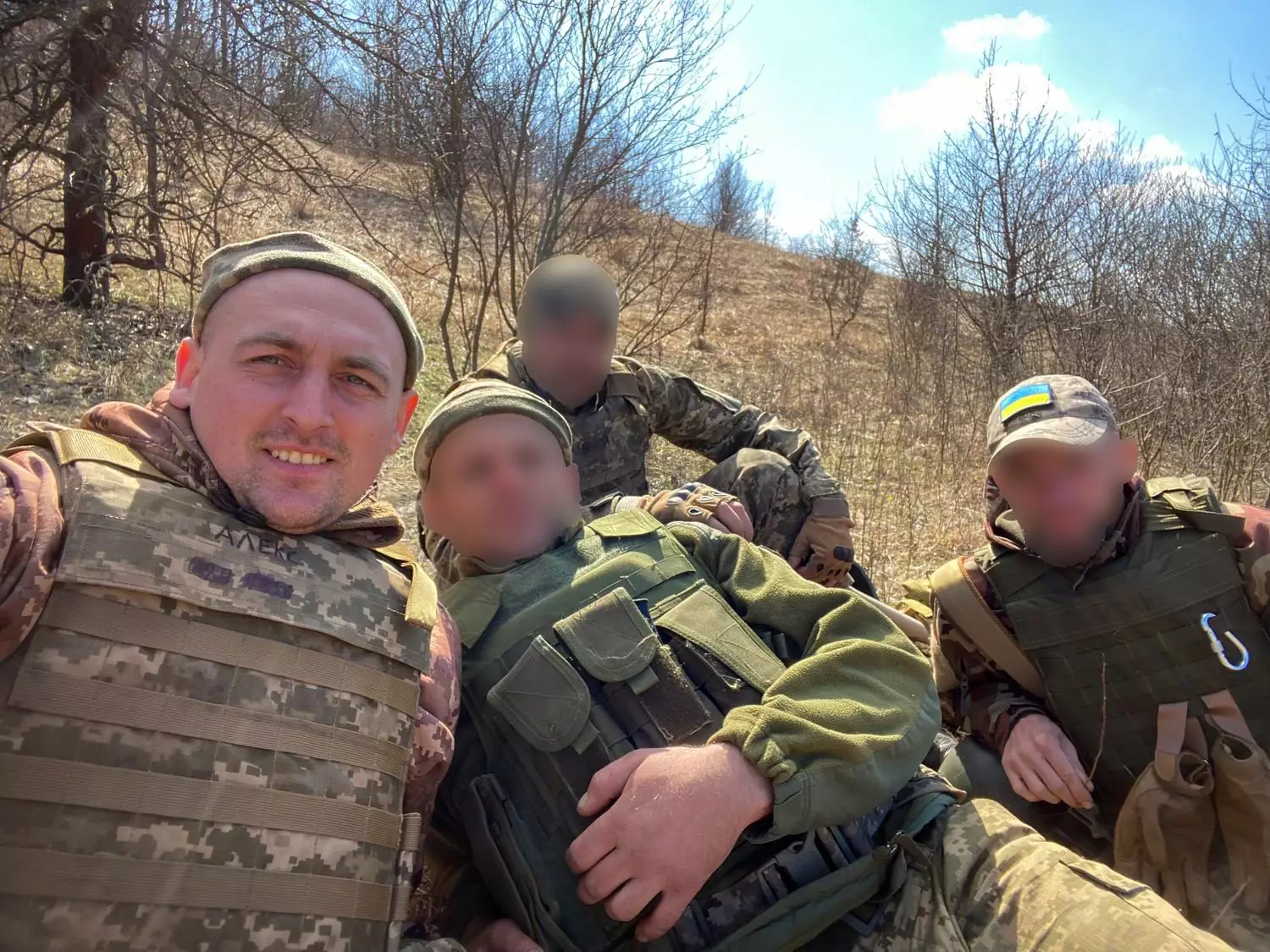 Ветеран у військовій формі з товаришами на природі, обговорюють стратегії та досвід бойових дій
