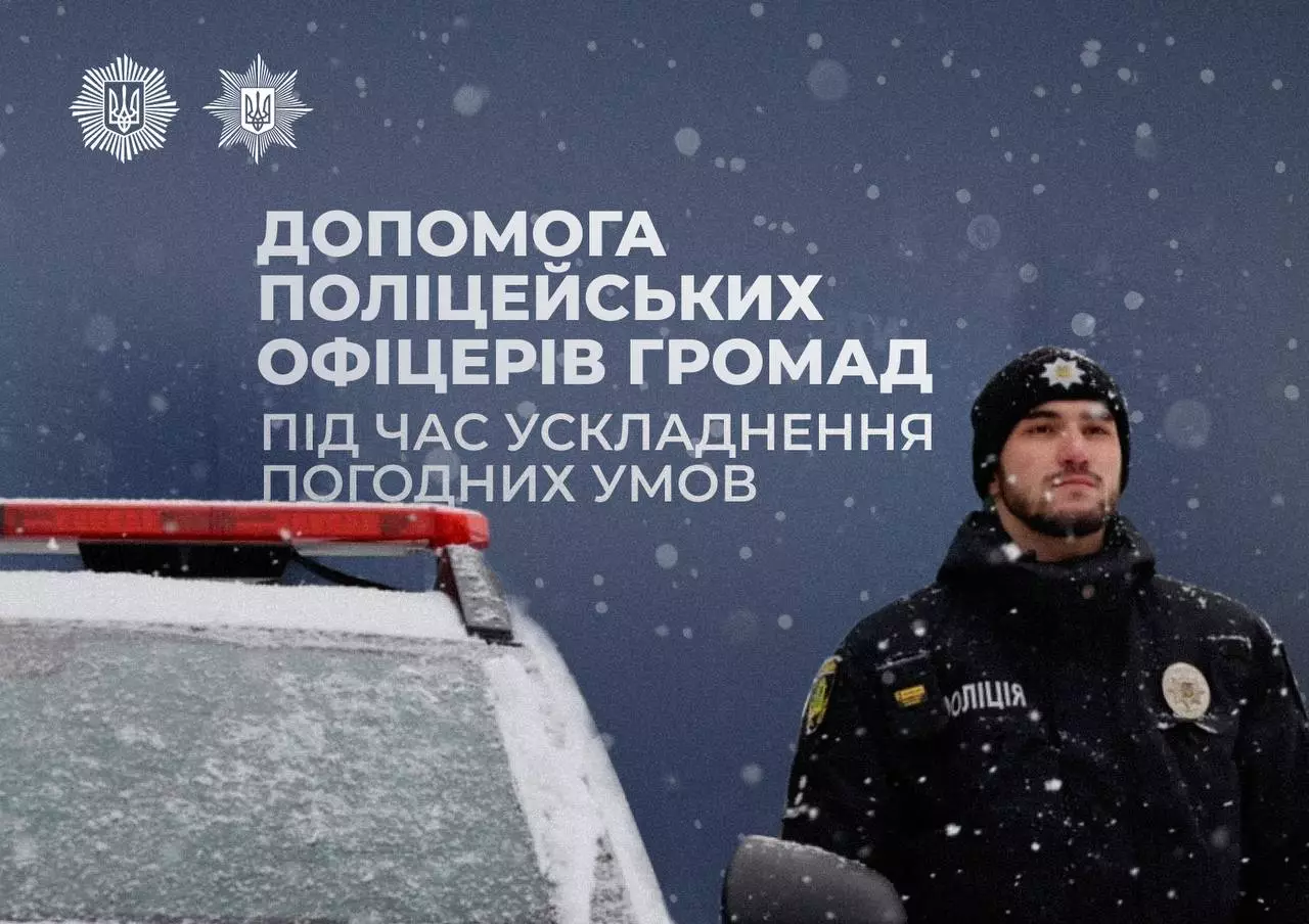 Поліцейський офіцер громади стоїть біля патрульної машини під час снігопаду, готовий допомогти