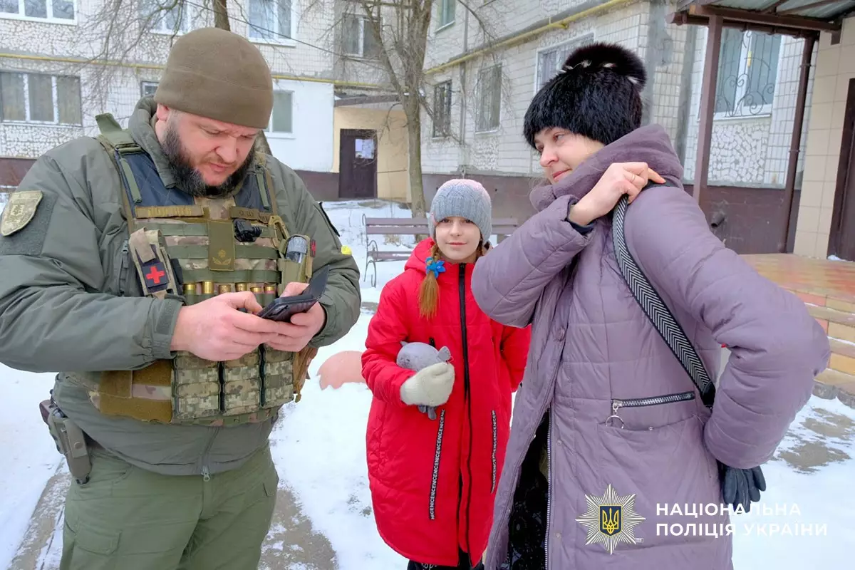Поліцейський у формі допомагає жінці з дитиною під час евакуації з Дружківки