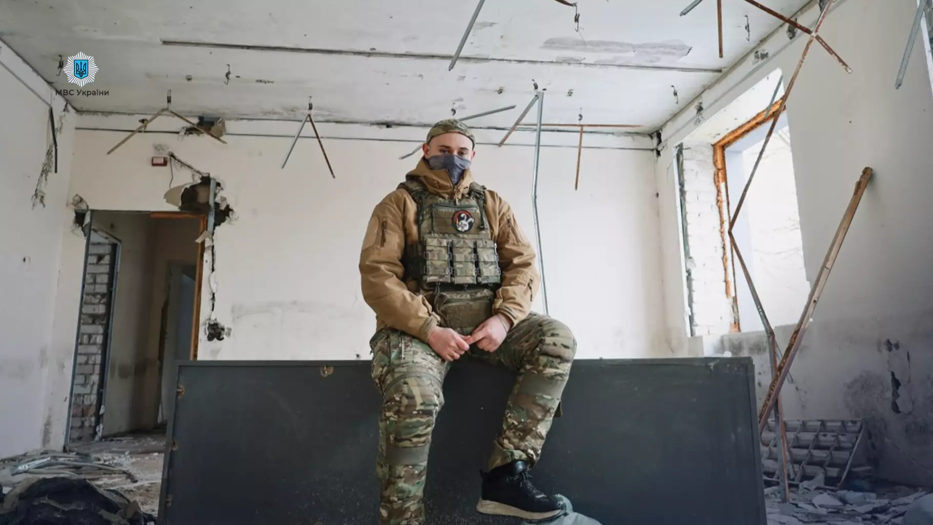 Прикордонник у військовій формі сидить у зруйнованій будівлі на лівобережжі Херсонщини