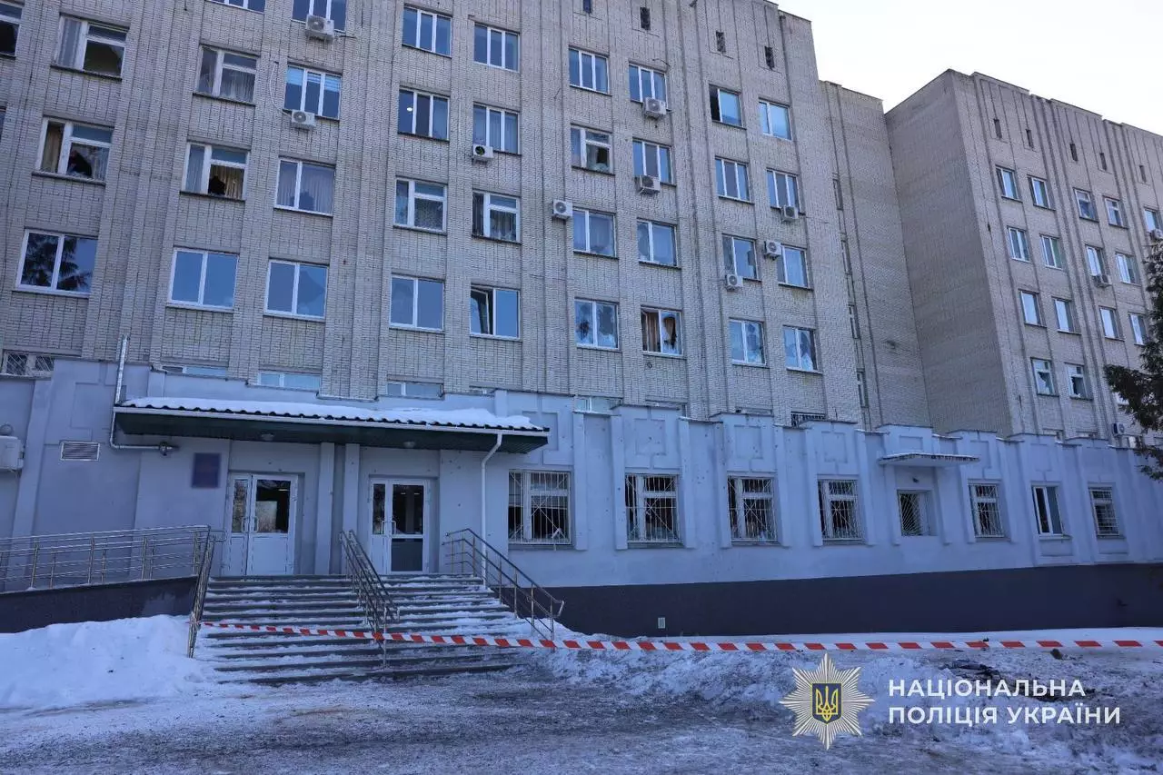 Будівля з пошкодженими вікнами після обстрілу, на передньому плані стрічка поліції України