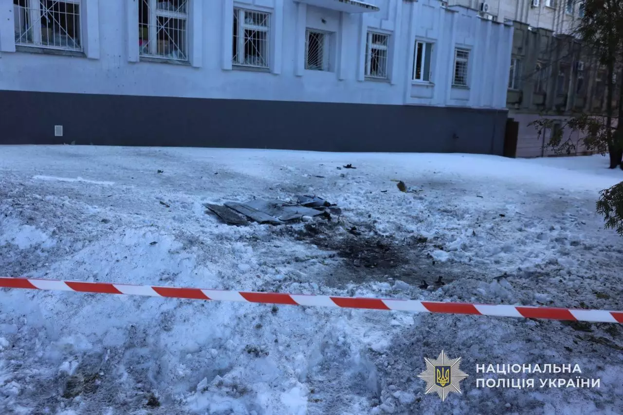 Зруйнована ділянка перед будівлею після обстрілу, огороджена поліцейською стрічкою