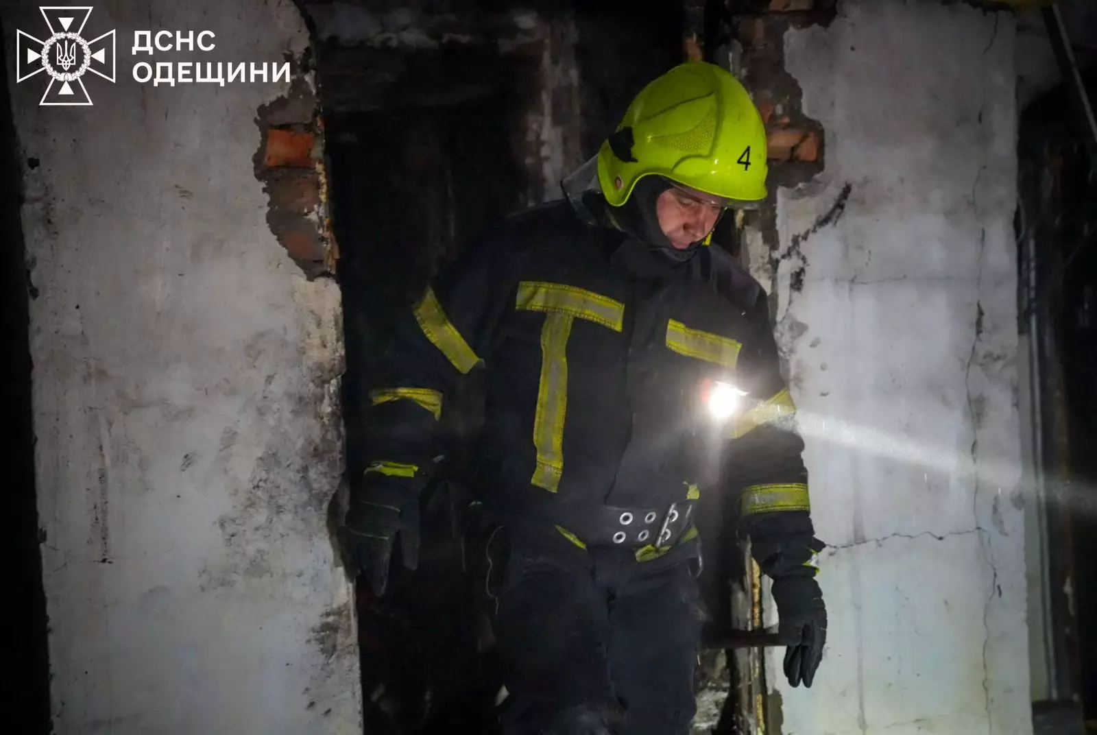 Рятувальник у захисному спорядженні оглядає пошкоджений будинок після обстрілу в Одеській області