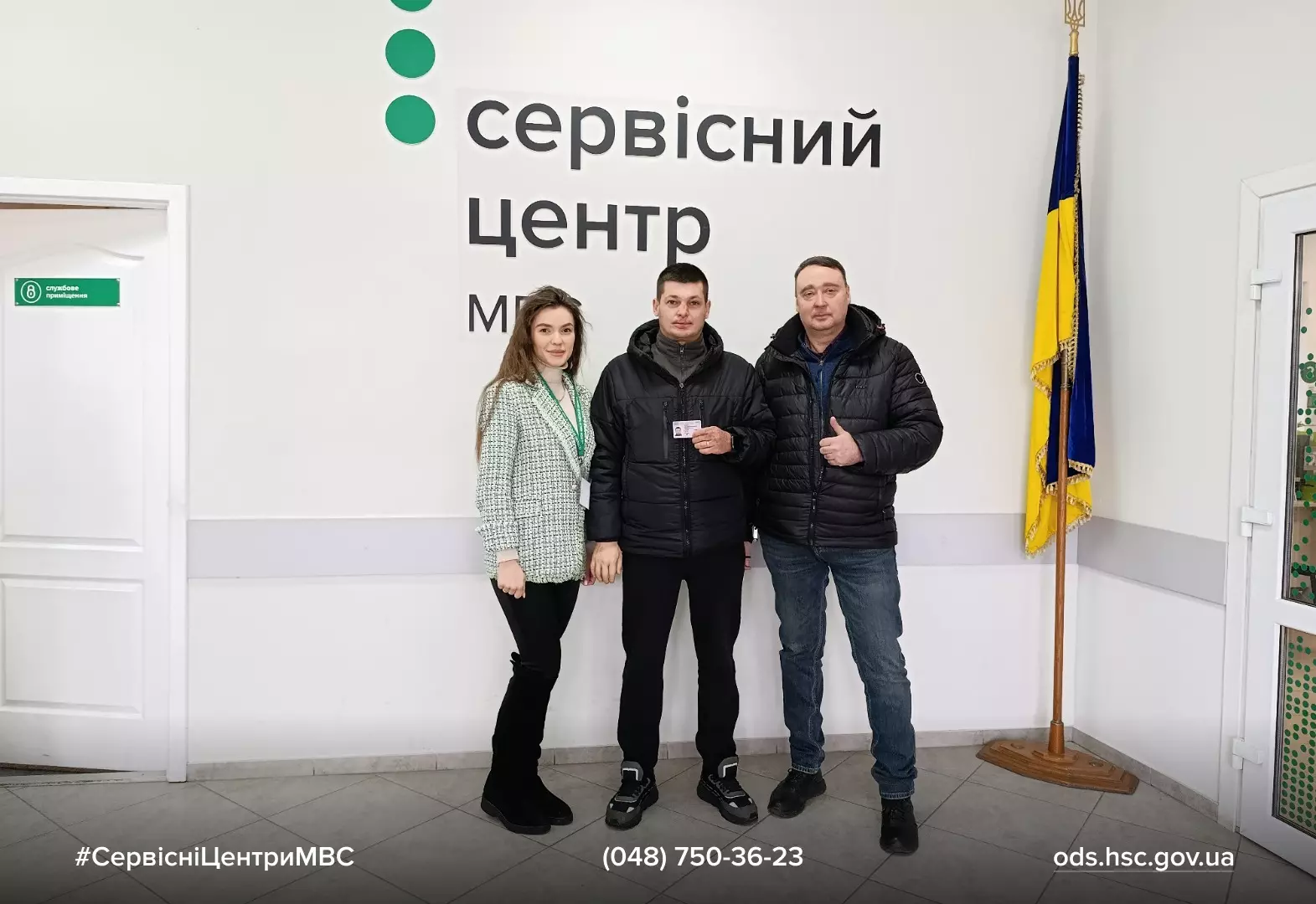 Випускник автошколи з посвідченням водія у сервісному центрі МВС, поруч двоє людей