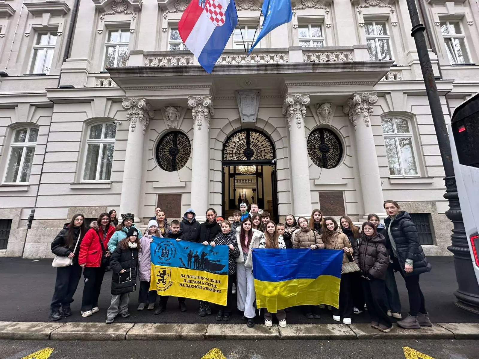 Діти з прапорами України та Хорватії перед будівлею в Загребі під час програми «Життя без мін