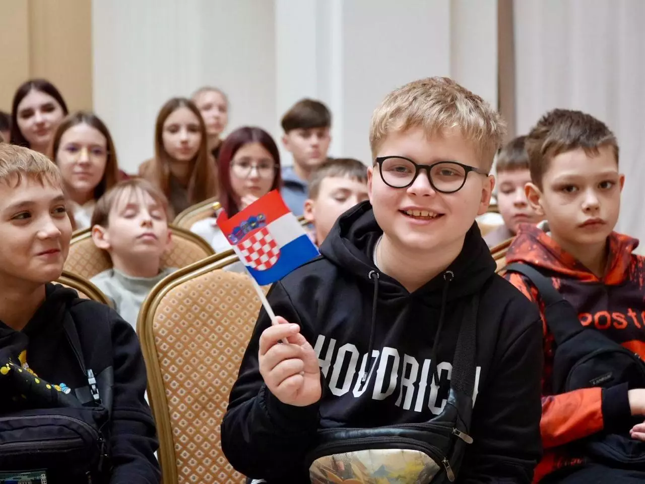 Діти з українських родин загиблих захисників тримають прапор Хорватії під час візиту в Загреб