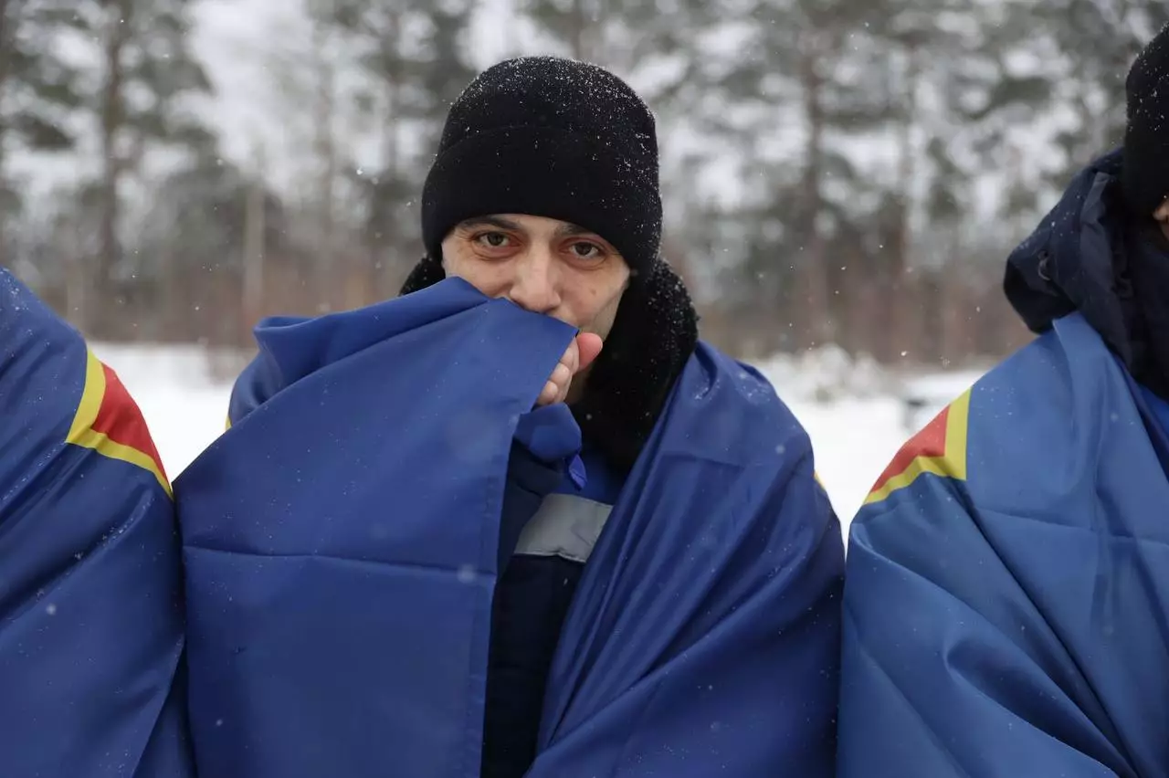 Троє військових у зимовому одязі під час повернення додому після обміну полоненими