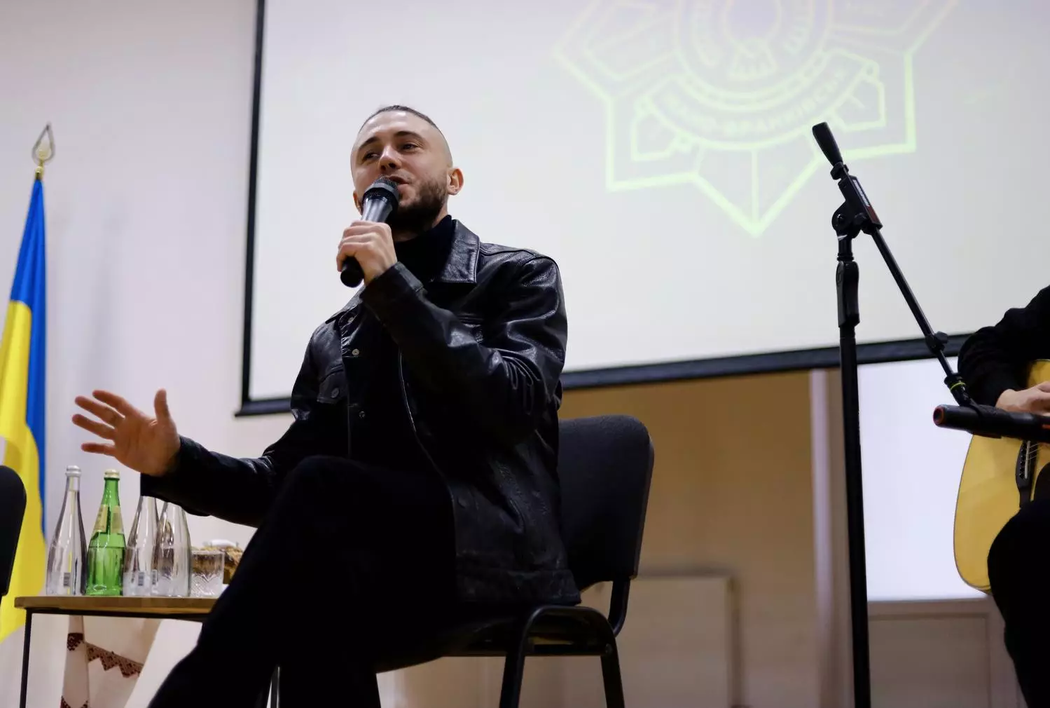 Лідер гурту «Антитіла» Тарас Тополя виступає перед ліцеїстами в Івано-Франківську, тримаючи мікрофон