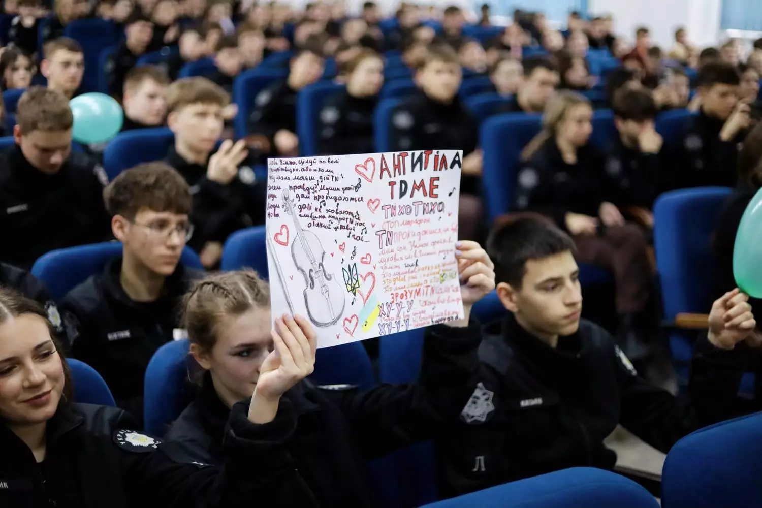 Ліцеїсти в залі тримають плакат на підтримку гурту «Антитіла» під час зустрічі в Івано-Франківську