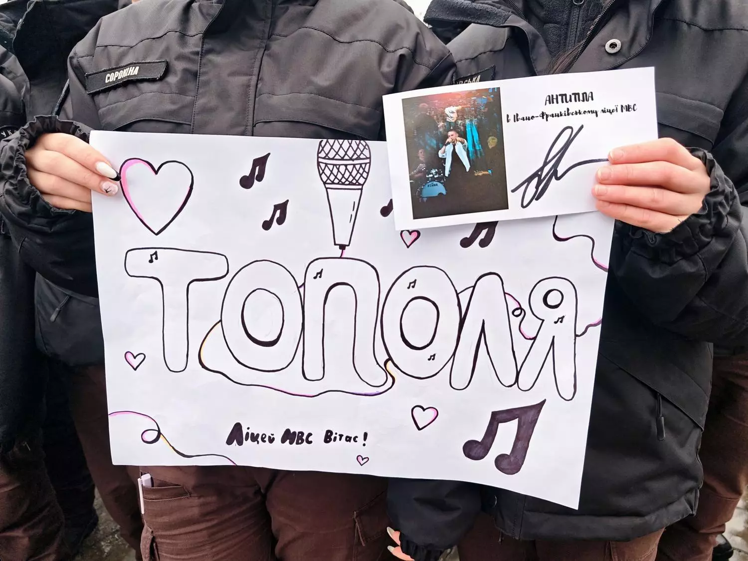 Ліцеїсти тримають плакат з написом "Тополя" та автографом гурту "Антитіла" під час зустрічі в ліцеї