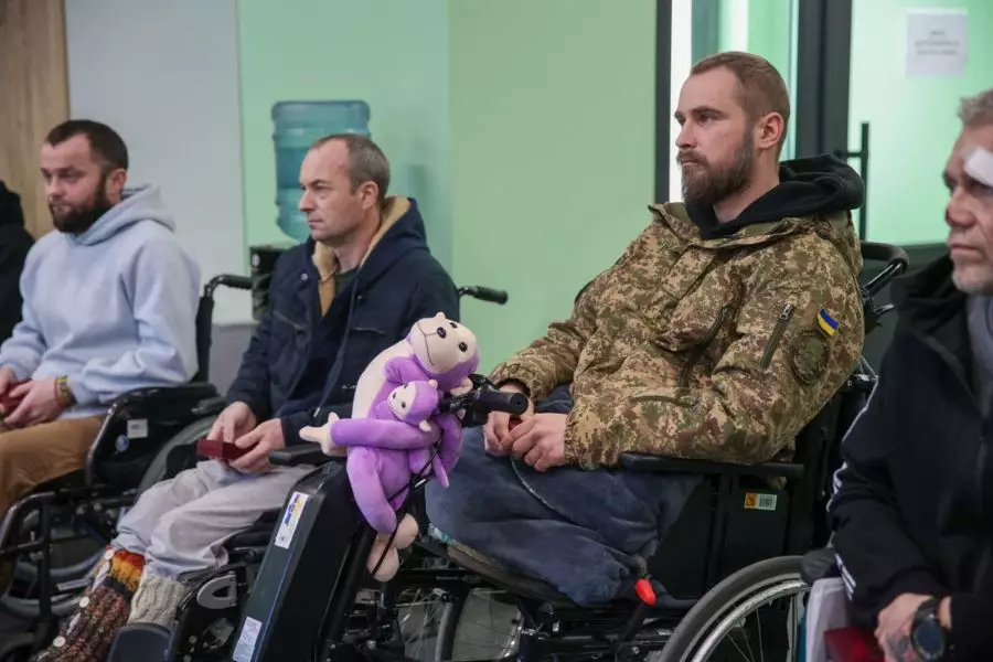 Військовослужбовці Нацгвардії України у візках, один з них тримає іграшку, проходять лікування