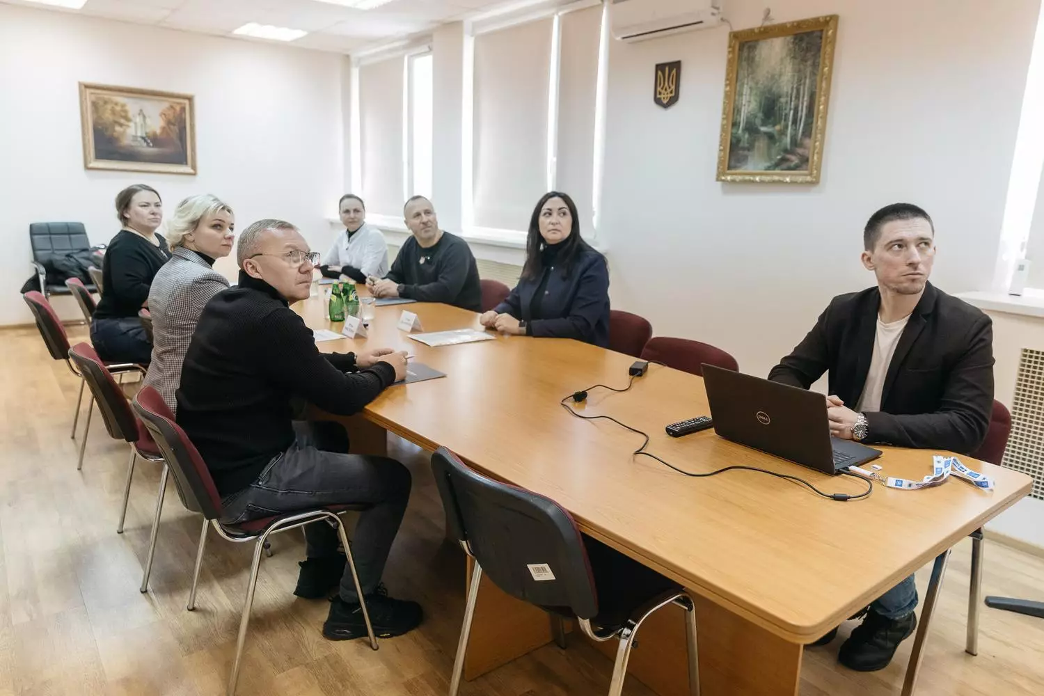 Люди за столом обговорюють впровадження електроприводів для крісел колісних у медичному центрі МВС