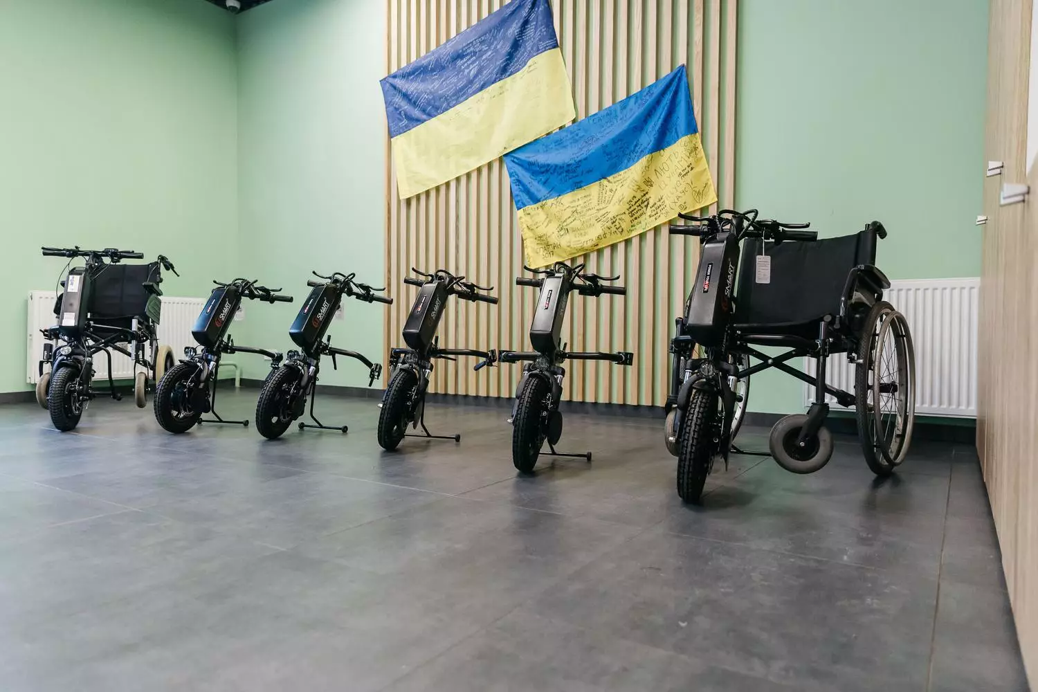 Електроприводи для крісел колісних у госпіталі МВС України на фоні українських прапорів