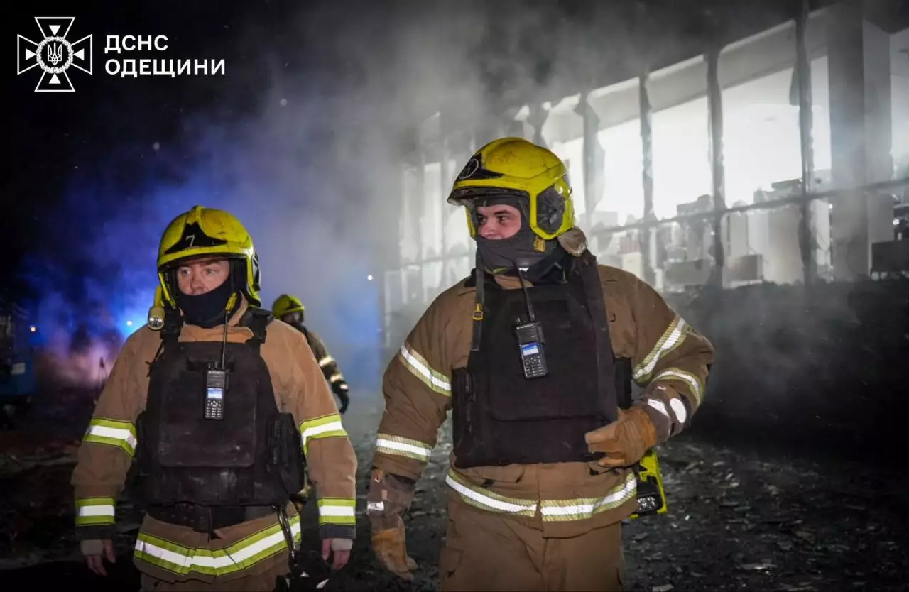 Рятувальники в захисному одязі на тлі зруйнованої будівлі після обстрілу в Україні