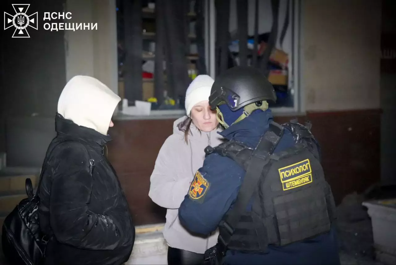 Поліцейський спілкується з двома жінками біля пошкодженої будівлі після обстрілу в Україні