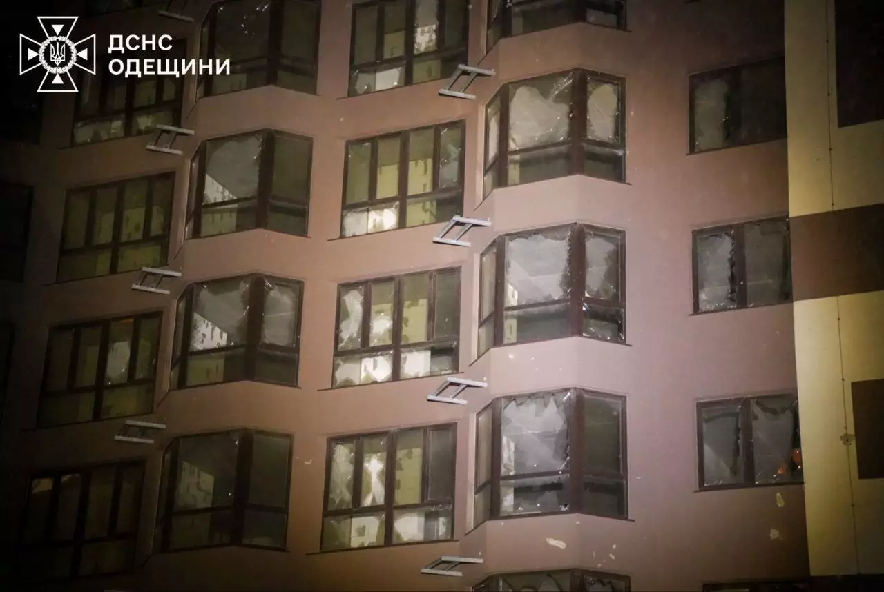 Пошкоджена багатоповерхівка внаслідок обстрілу, розбиті вікна, нічний час, робота рятувальників