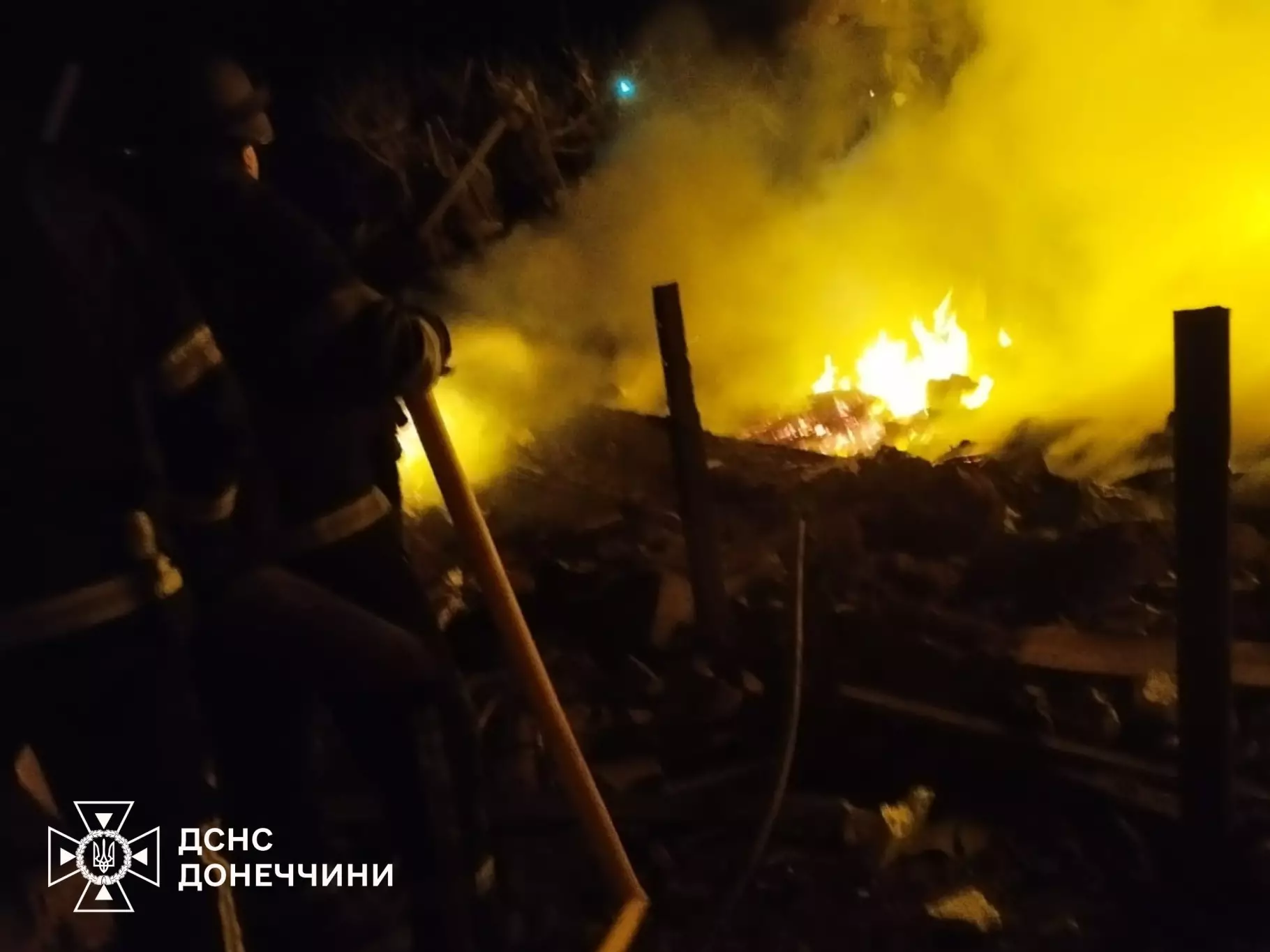 Рятувальники гасять пожежу вночі після обстрілу, густий дим і вогонь на місці руйнувань