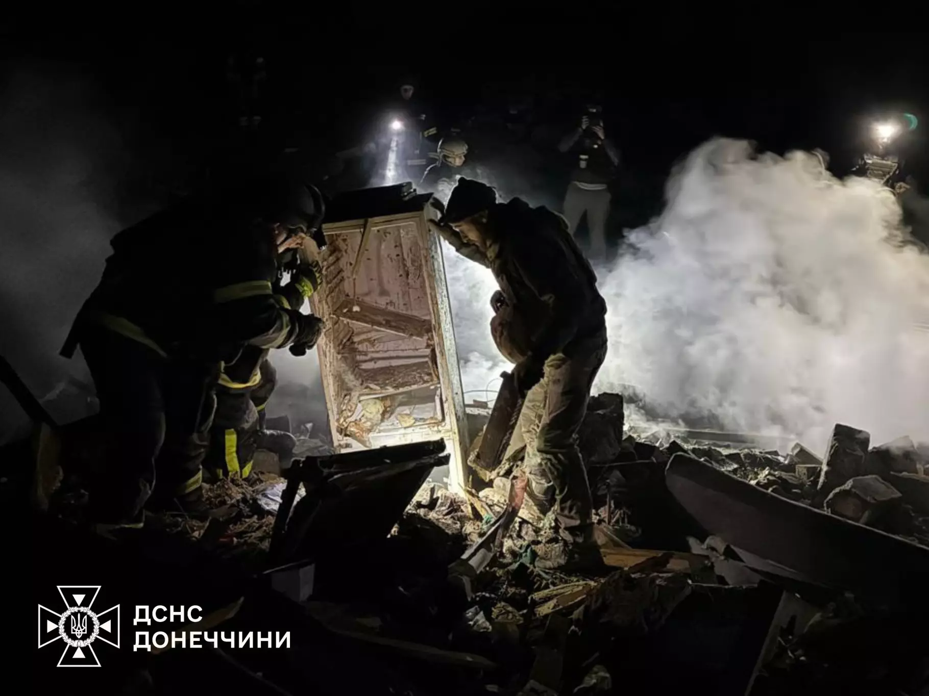 Рятувальники працюють на місці руйнувань після нічного обстрілу, дим і уламки навколо