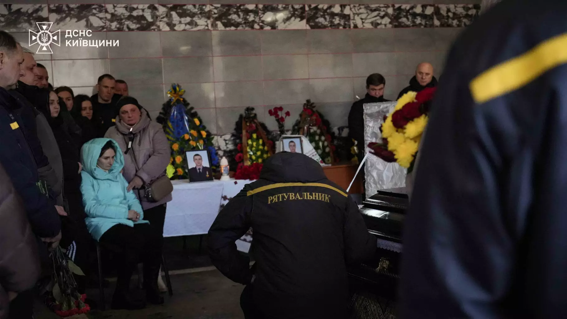 Рятувальники та люди прощаються з загиблим колегою Михайлом Проценком у залі з вінками та фото
