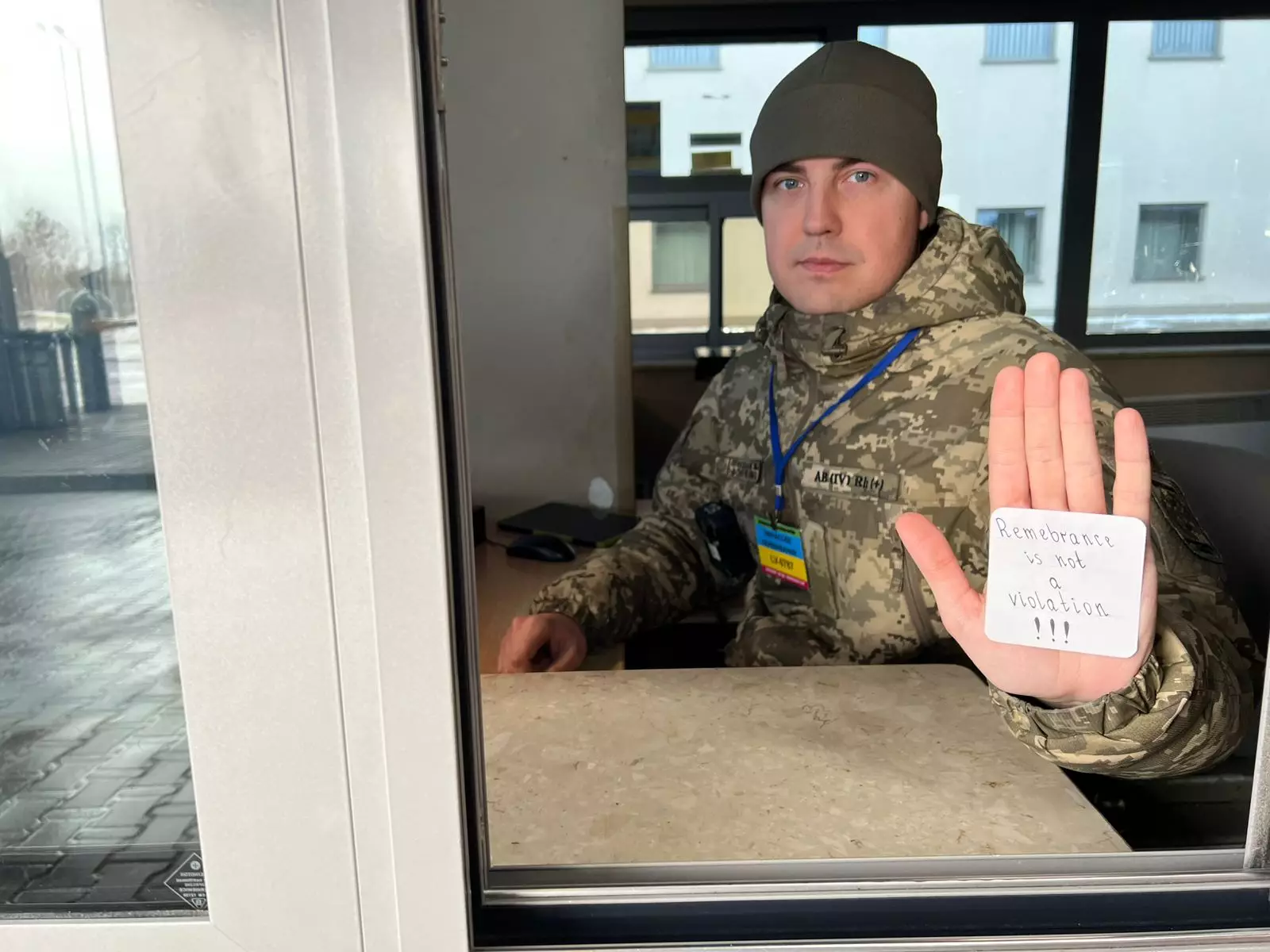 Військовослужбовець у формі Держприкордонслужби тримає напис "Remembrance is not a violation