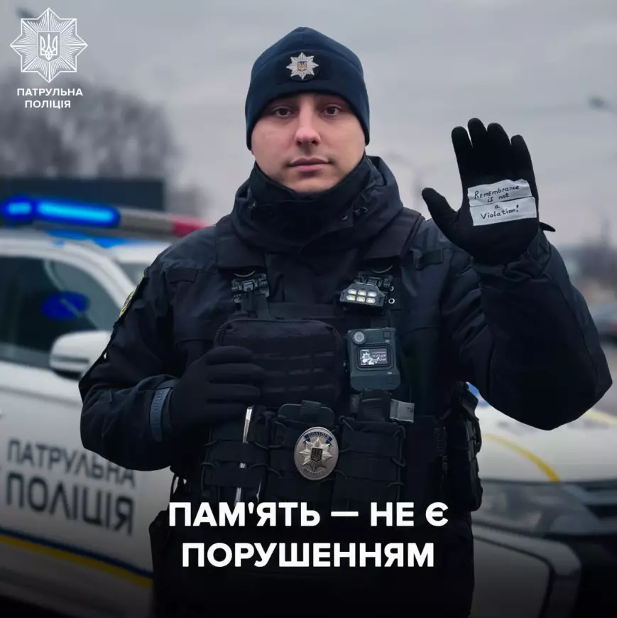 Поліцейський у формі з написом «Пам'ять — не є порушенням», тримає руку з підтримкою Гераскевича