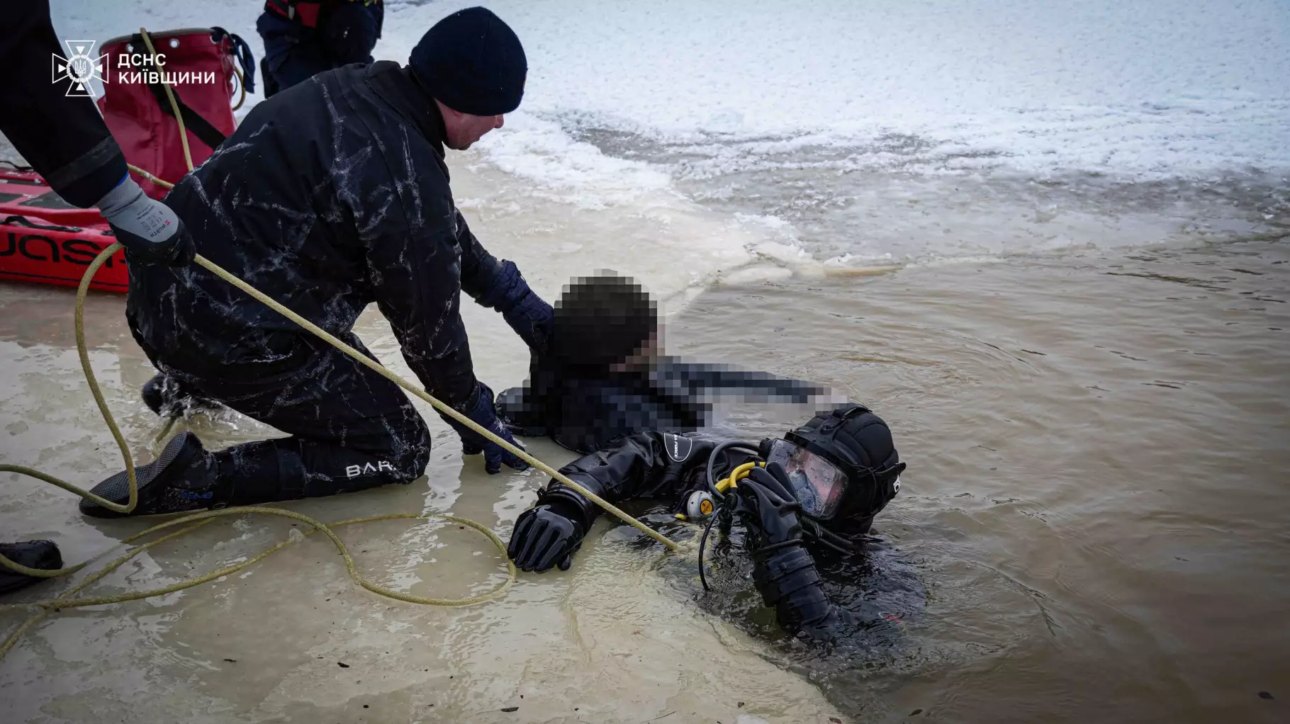 Рятувальники ДСНС витягують водолаза з крижаної води під час пошукової операції на Київщині
