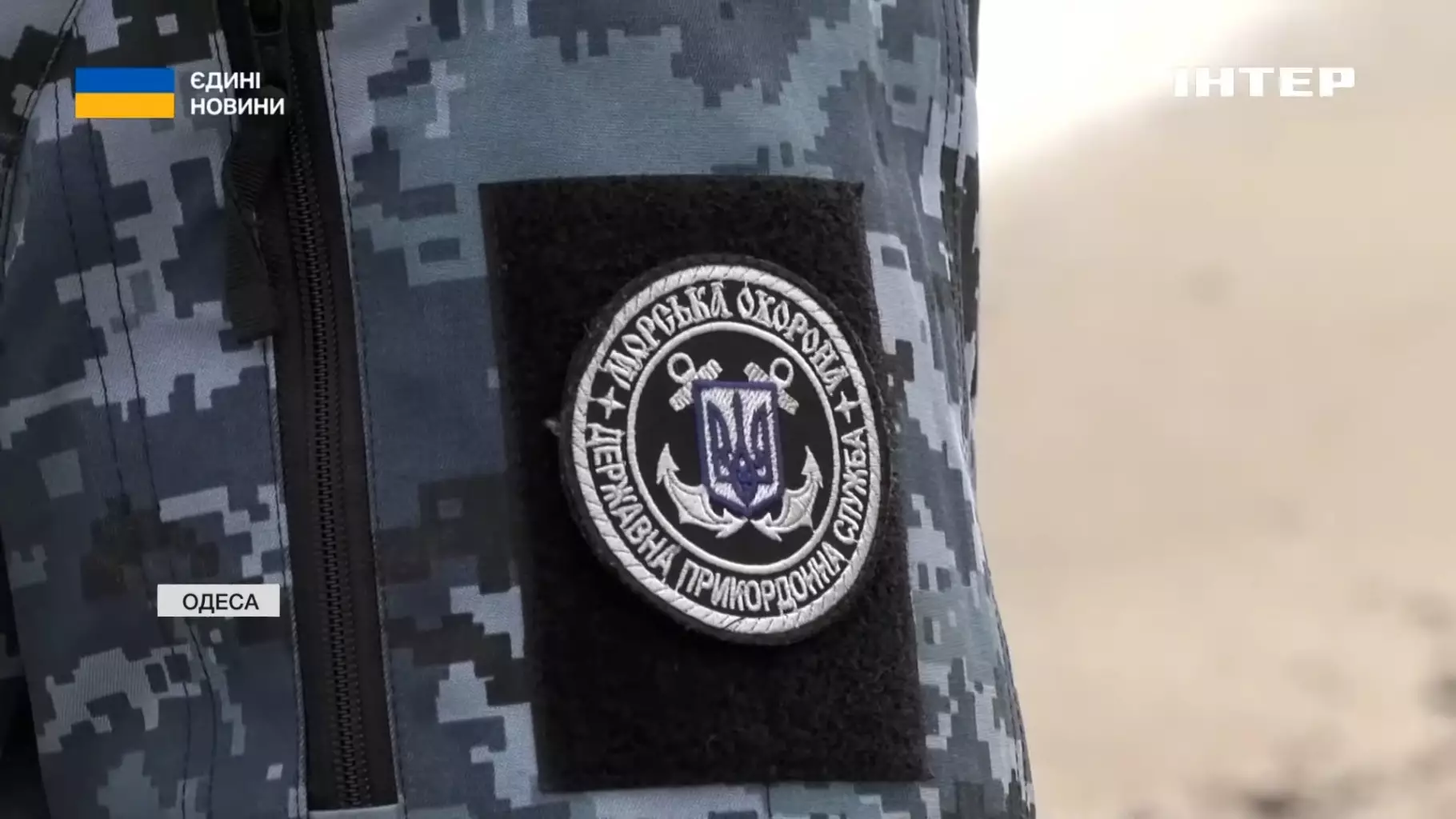 Нашивка Морської охорони на формі прикордонника в камуфляжі на фоні пляжу в Одесі
