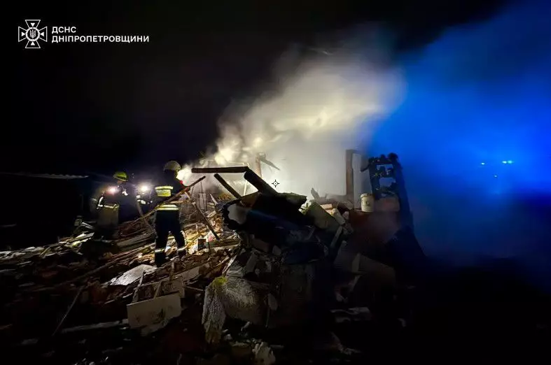 Рятувальники працюють на місці руйнувань після обстрілу, дим піднімається над уламками будівлі