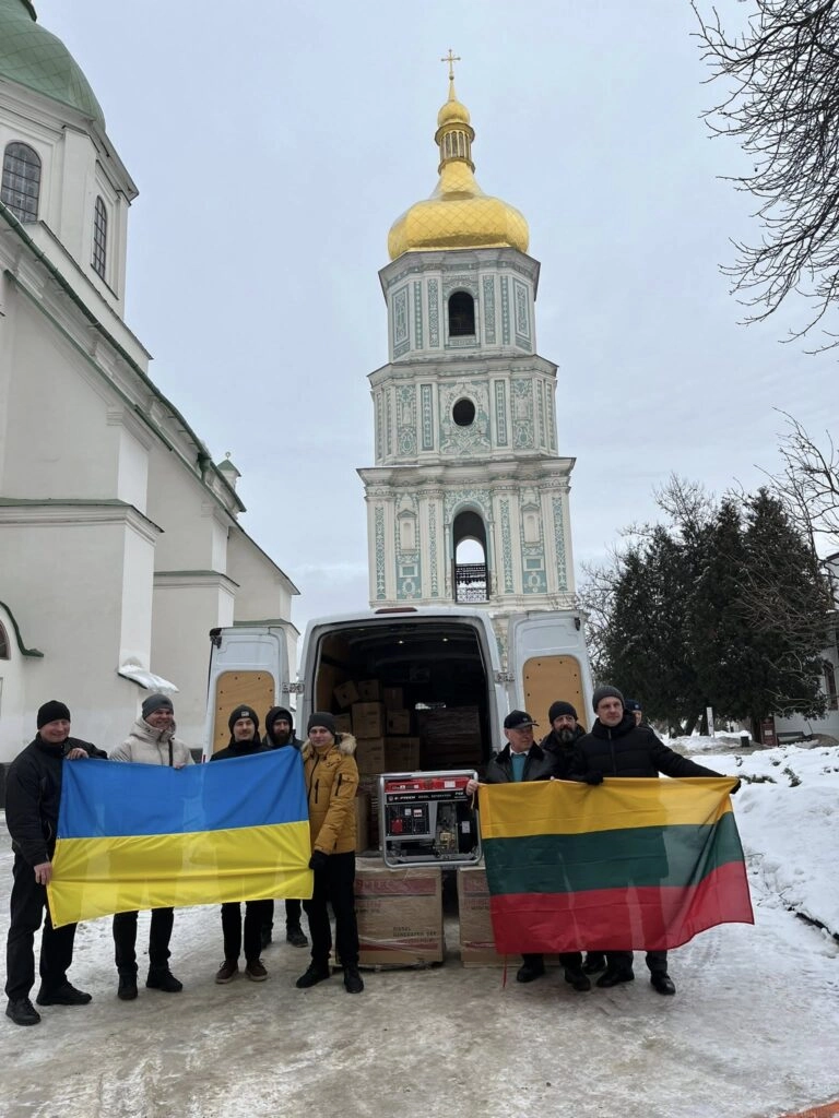 Люди з прапорами України та Литви біля фургона з обладнанням на тлі Софії Київської